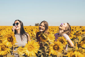 Friends in sunflower field wearing Noz reef safe spf sunscreen on face